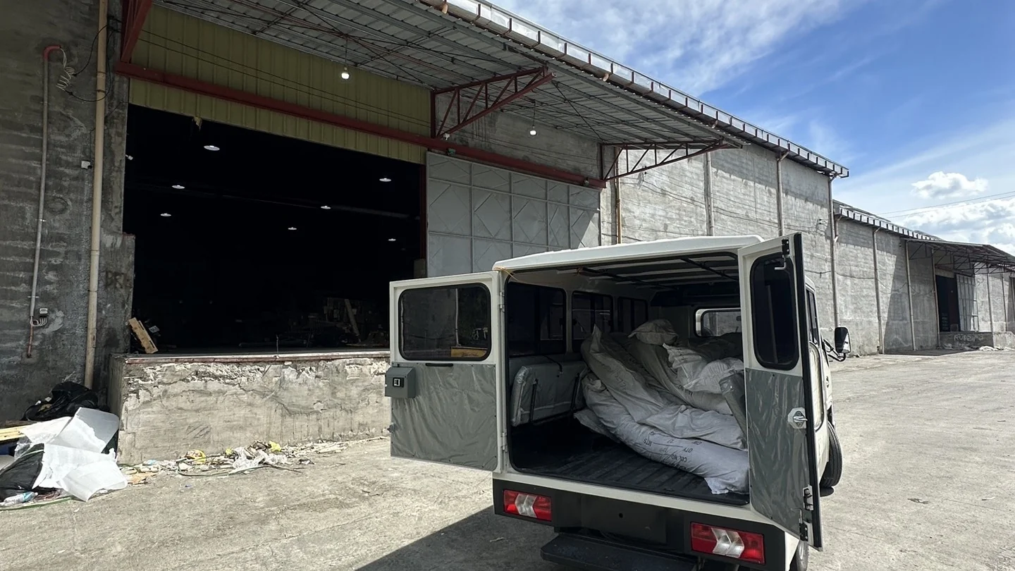 Cargo van docked at warehouse terminal with doors open, ready for local delivery